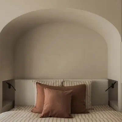 Boogvormige nis met bed tussen witte kastenwanden, Appartement in Nieuwpoort, interieur Laura Calleeuw