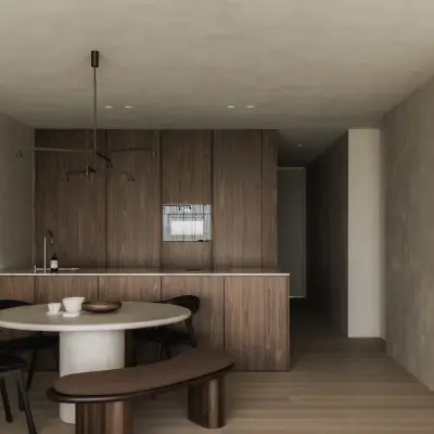 Keuken met houten wand, ronde eettafel en groot schilderij naast de gang, Appartement in Nieuwpoort, interieur Laura Calleeuw