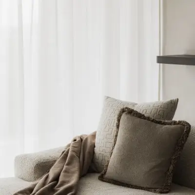 Sofa met plaid en kussens in de leefruimte, Appartement in Nieuwpoort, interieur Laura Calleeuw