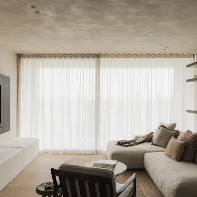 Zithoek met sofa, fauteuil en open rekken voor grote ramen met vitrage, Appartement in Nieuwpoort, interieur Laura Calleeuw