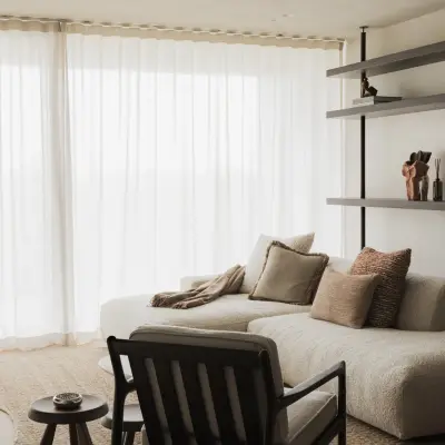 Zithoek met sofa, houten fauteuil en stalen rekken, Appartement in Nieuwpoort, interieur Laura Calleeuw