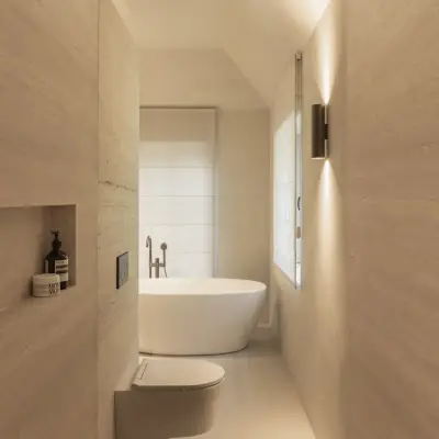 Smalle badkamer met regendouche, hangend toilet en vrijstaand bad voor het raam, Gezinsvilla in Heusden-Zolder, interieur Laura Calleeuw