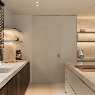 Keuken met natuurstenen werkblad en spoelbak, kookplaat en een verborgen kastdeur, Gezinsvilla in Heusden-Zolder, interieur Laura Calleeuw