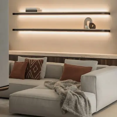 Sofa met plaid en kussens onder planken met een designlamp, Gezinsvilla in Heusden-Zolder, interieur Laura Calleeuw