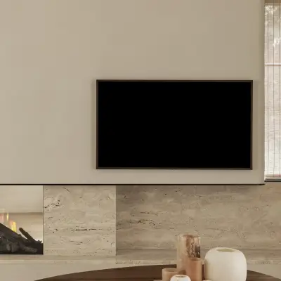 Televisie in een gepleisterd volume boven de natuurstenen haard en salontafel, Gezinsvilla in Heusden-Zolder, interieur Laura Calleeuw