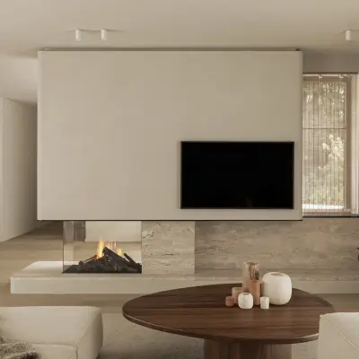 Leefruimte met televisie boven een open haard in natuursteen en een ovale houten salontafel, Gezinsvilla in Heusden-Zolder, interieur Laura Calleeuw