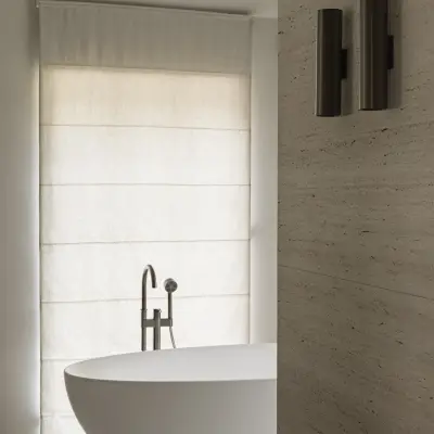 Vrijstaand bad met badkraan, wandlamp en roman blind bij het raam, Gezinsvilla in Heusden-Zolder, interieur Laura Calleeuw