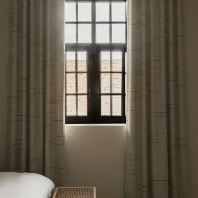 Gordijn voor een zwart raam met een rotan bank aan het bed, Hoeve in Westkapelle, interieur Laura Calleeuw