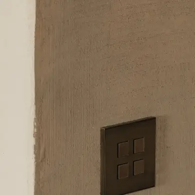 Detail van een bronzen lichtschakelaar op een leempleisterwand, Hoeve in Westkapelle, interieur Laura Calleeuw