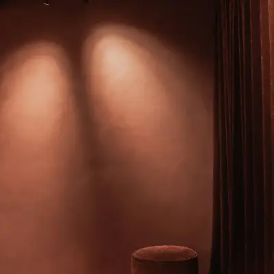 Ronde poef naast een gordijn in een terracotta ruimte met spots, Hoeve in Westkapelle, interieur Laura Calleeuw