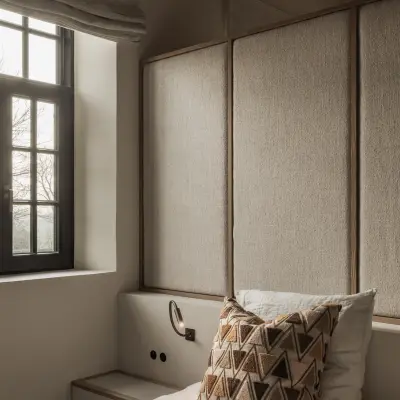 Slaapkamer met hoofdbord, kussen en een zwart raam met roman blind, Hoeve in Westkapelle, interieur Laura Calleeuw