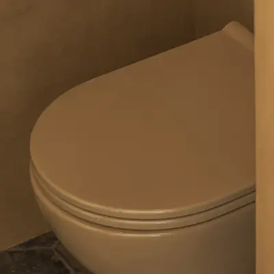 Hangtoilet in de kleur van de okergele leempleisterwand, Hoeve in Westkapelle, interieur Laura Calleeuw
