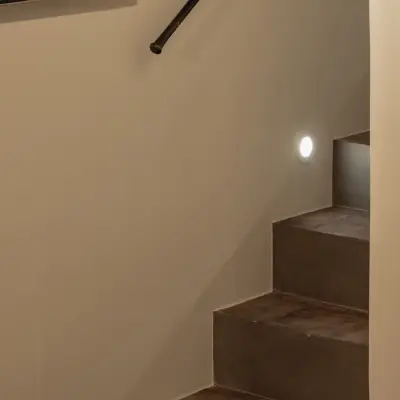 Trap met zwarte leuning en ingewerkt licht langs de treden, Hoeve in Westkapelle, interieur Laura Calleeuw