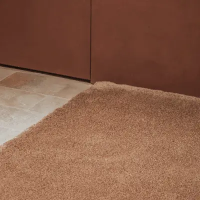 Wollen tapijt op de vloer langs de terracotta wand, Hoeve in Westkapelle, interieur Laura Calleeuw