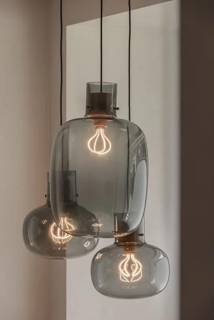 Grijze glazen hanglampen met zichtbare gloeilamp boven de ontbijthoek, Herenhuis in Roeselare, interieur Laura Calleeuw