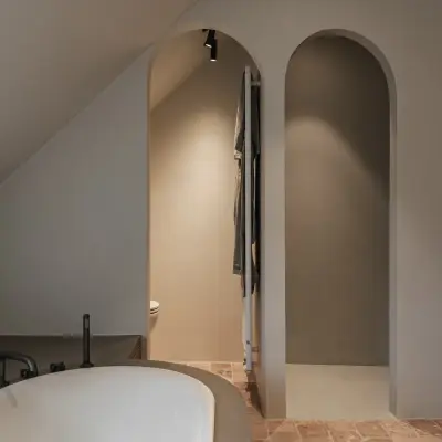 Badkamer met vrijstaand bad en twee boogvormige nissen, Schuur in Westkapelle, interieur Laura Calleeuw