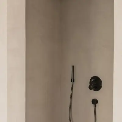 Douche met regendouche en thermostaatkraan in microcement, Schuur in Westkapelle, interieur Laura Calleeuw