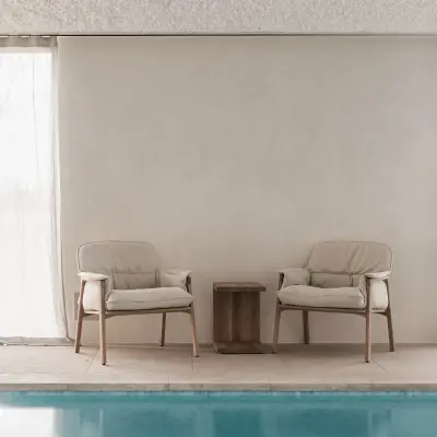 Zithoek met fauteuils en houten bijzettafel naast het zwembad, Schuur in Westkapelle, interieur Laura Calleeuw