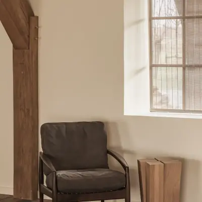 Fauteuil en houten bijzettafel naast het raam, Schuur in Westkapelle, interieur Laura Calleeuw