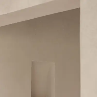 Smalle gang met verlichte nis in microcement, Schuur in Westkapelle, interieur Laura Calleeuw