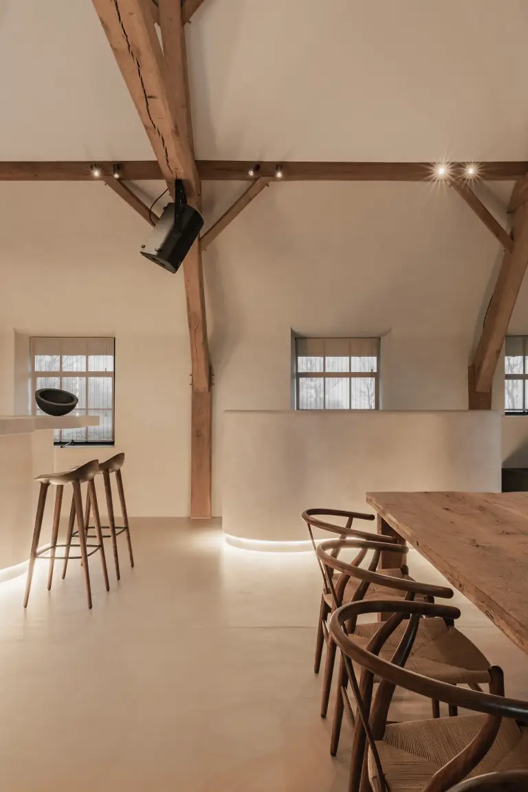 Keuken en eethoek met eikenhouten tafel en wishbone stoelen onder de spanten, where heritage finds a new purpose, interieur Laura Calleeuw