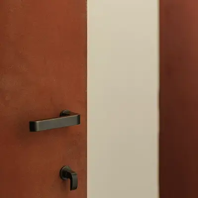 Rode kalkverf met bruin marmer en zwarte deurklink, Schuur in Westkapelle, interieur Laura Calleeuw