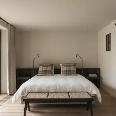 Slaapkamer met bed, zwarte schuifdeur en terrasdeur met uitzicht op de weide, Schuur in Westkapelle, interieur Laura Calleeuw