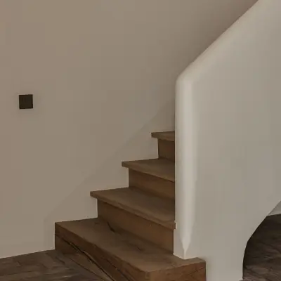 Trap met eikenhouten treden, gestucte leuning en vloer in visgraat gebakken baksteen, Schuur in Westkapelle, interieur Laura Calleeuw