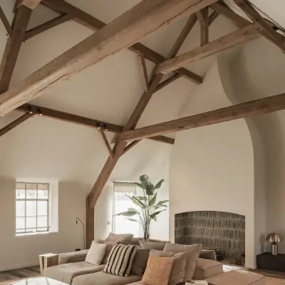 Woonkamer onder het spantendak met modulaire hoekzetel en schouw, Schuur in Westkapelle, interieur Laura Calleeuw