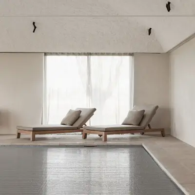 Zwembad met ligstoelen, fauteuils en rolluik over het water, Schuur in Westkapelle, interieur Laura Calleeuw