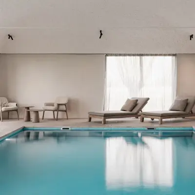 Zwembad met ligstoelen, fauteuils en rolluik over het water, Schuur in Westkapelle, interieur Laura Calleeuw